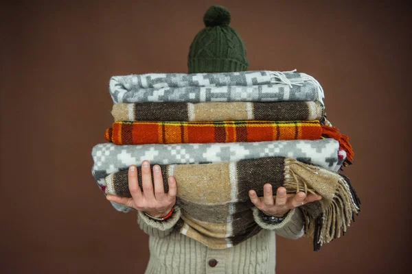 Homem segurando pilha de cobertores — Fotografia de Stock