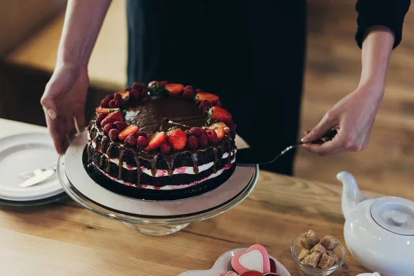 Frau nimmt Stück Kuchen — Stockfoto