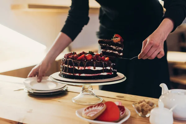 Frau nimmt Stück Kuchen — Stockfoto