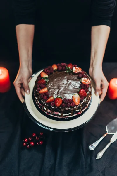 Donna mettendo torta stand sul tavolo — Foto stock