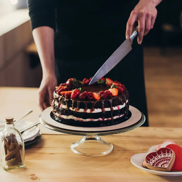 Frau schneidet Schokoladenkuchen — Stockfoto