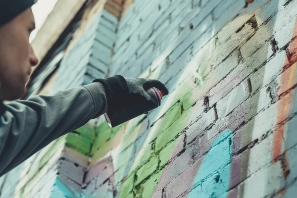 Cropped view of man painting colorful graffiti on wall — Stock Photo