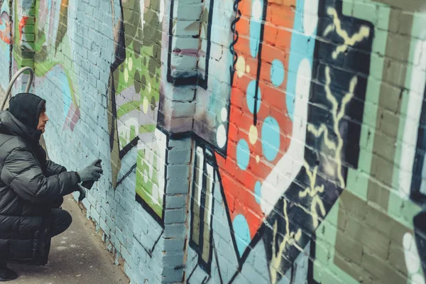 Homem pintando graffiti colorido na parede — Fotografia de Stock