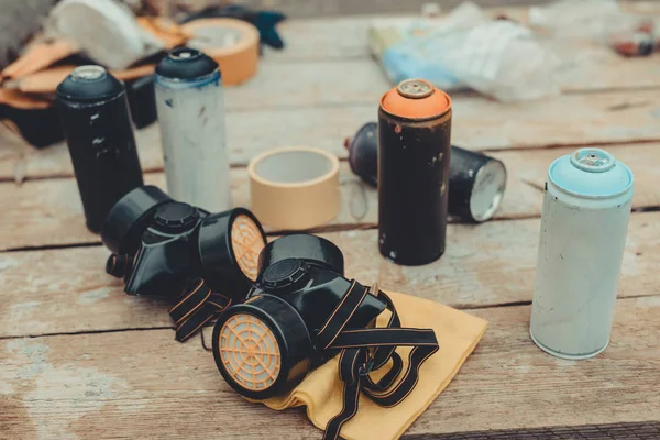 Respirators and cans with colorful spray paint for graffiti — Stock Photo