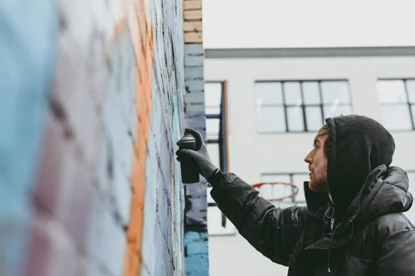 Homem pintando graffiti colorido na parede — Fotografia de Stock