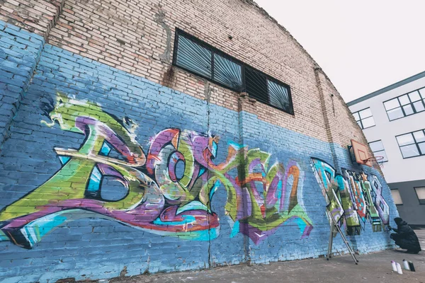 Artista callejero pintando graffiti colorido en la pared - foto de stock