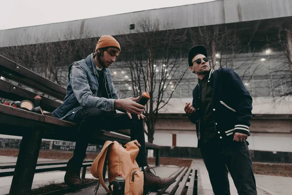 Street artists holding cans with spray paint in city — Stock Photo