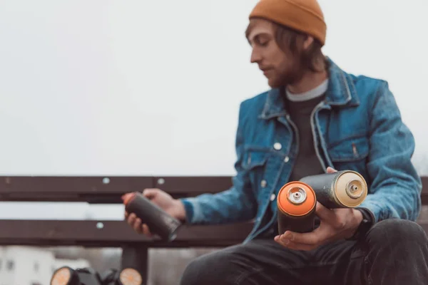 Male street artist holding cans with spray paint — Stock Photo