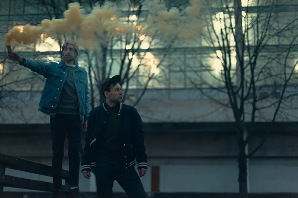 Young men with smoke bomb in city — Stock Photo