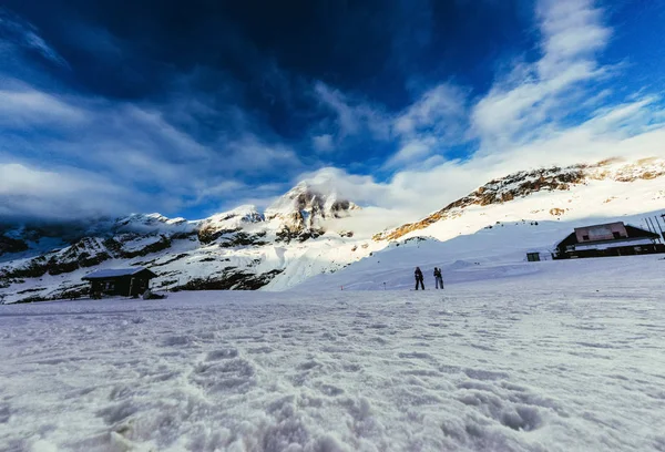 Tranquil mountains landscape under blue sky with tourists walking on snow, Austria — Stock Photo