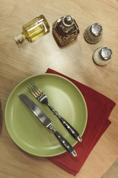 Top view of arranged cutlery, napkin and spices on wooden surface — Stock Photo