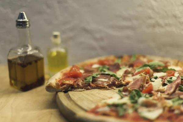 Enfoque selectivo de sabrosa pizza italiana casera sobre tabla de madera - foto de stock