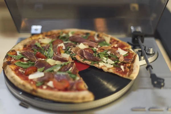 Vista de cerca de la pizza italiana en el reproductor de discos de vinilo retro - foto de stock