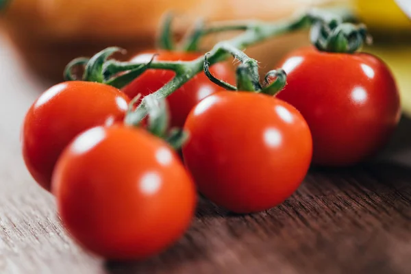 Vue rapprochée de tomates cerises biologiques fraîches mûres sur une table en bois — Photo de stock