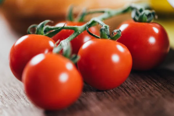 Vista de cerca de tomates cherry orgánicos maduros frescos sobre una mesa de madera - foto de stock