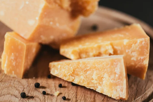 Крупним планом смачний пармезанський сир з перцем на дерев'яній обробній дошці — стокове фото