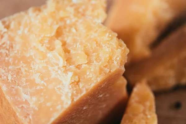 Крупним планом смачний пармезанський сир на дерев'яній обробній дошці — стокове фото