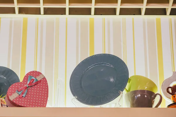 Low angle view of decorative plates, cups and heart shaped box in restaurant — Stock Photo