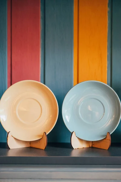 Close-up view of two decorative empty plates near colorful wall in restaurant — Stock Photo