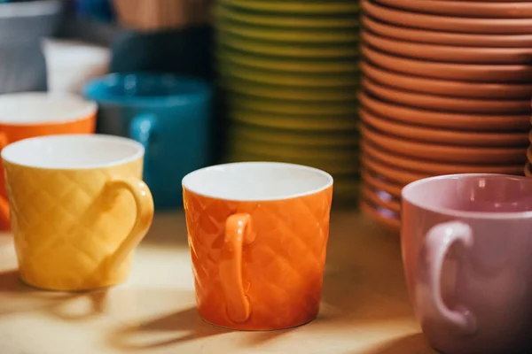 Vue rapprochée des tasses et assiettes colorées vides sur le dessus de la table — Photo de stock