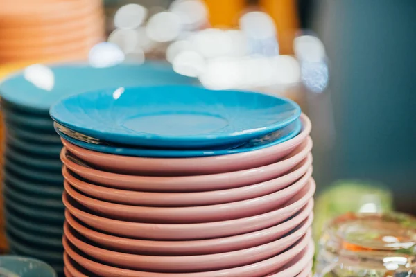 Vue rapprochée des assiettes empilées bleues et roses propres dans la cuisine — Photo de stock