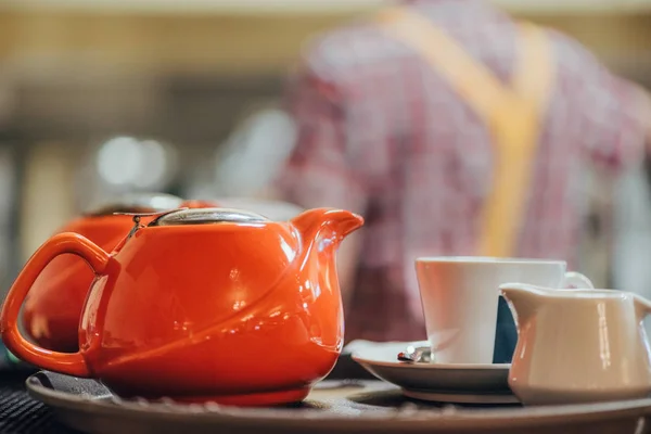 Close-up view of red porcelain kettle, cup and white jug on table — Stock Photo