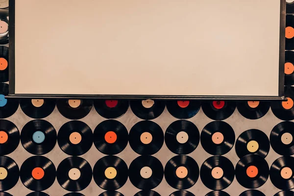 Vista superior de fundo feita a partir de registros de vinil e quadro em branco — Fotografia de Stock