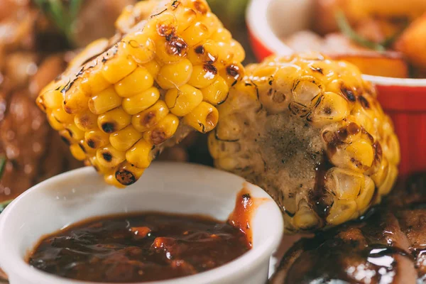 Vista de cerca del delicioso maíz asado con salsa de barbacoa y pollo a la parrilla - foto de stock