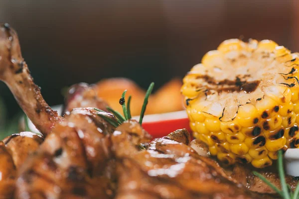 Vista de cerca del delicioso pollo asado con romero y maíz - foto de stock