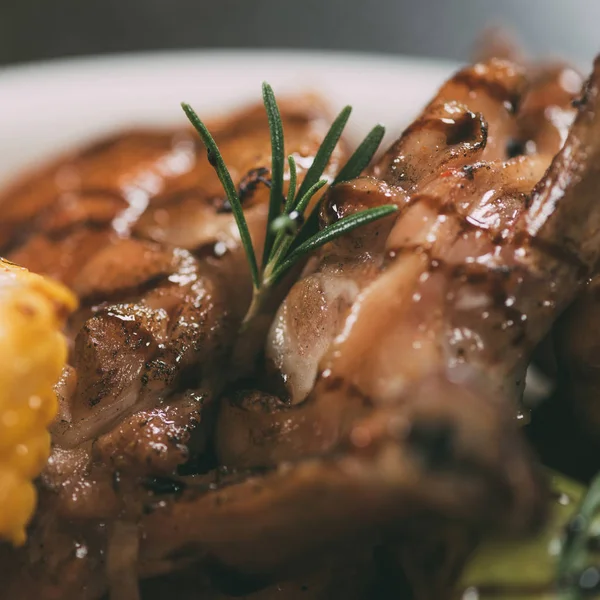 Close-up view of delicious grilled chicken with rosemary on plate — Stock Photo