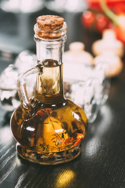 Close-up view of olive oil with spices in glass bottle — Stock Photo