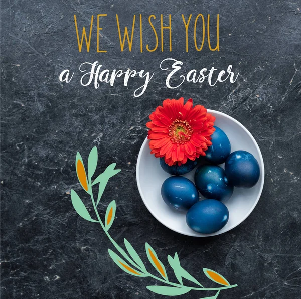 Painted chicken eggs on plate with happy easter lettering on dark background — Stock Photo