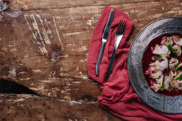 Ceviche gourmet con dorado in piatto, forchetta e coltello sul tavolo di legno — Foto stock