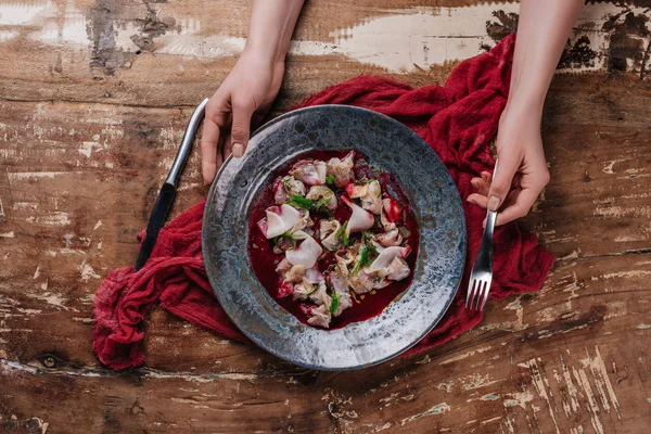 Cropped shot of human hands and delicious ceviche with dorado in plate — Stock Photo