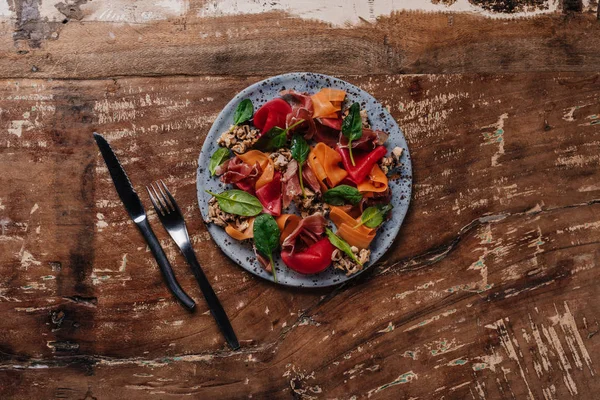 Vista superior de la deliciosa ensalada con mejillones, verduras y jamón en el plato - foto de stock