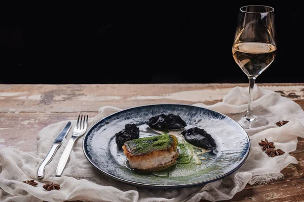 Vista de cerca de la lijadora frita gourmet y la copa de vino en la mesa de madera - foto de stock