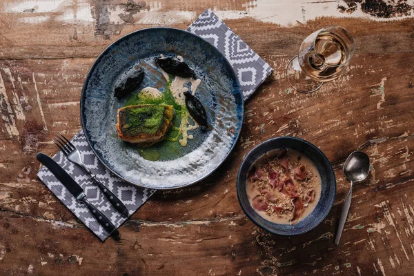 Vue du dessus de délicieuse soupe à la crème avec jamon et sandre frite sur table en bois — Photo de stock