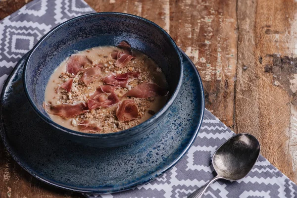 Vista close-up de deliciosa sopa de creme com batatas fritas e jamon — Fotografia de Stock