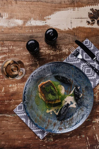 Vista superior de delicioso pescado frito y copa de vino en la mesa de madera - foto de stock
