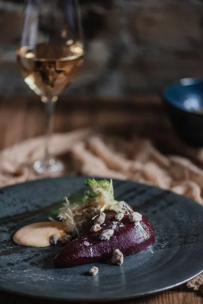 Close-up view of delicious pear in wine with cream sauce and caramelized pistachios — Stock Photo