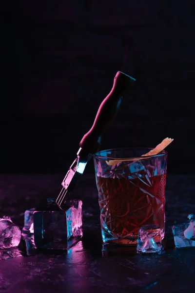 Vista de perto de vidro com delicioso cocktail boulevardier alcoólico e cubos de gelo — Fotografia de Stock