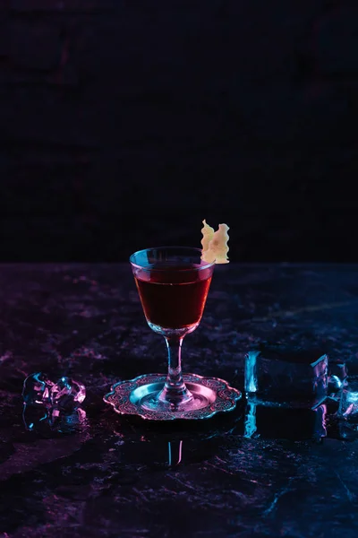 Close-up view of glass with delicious alcohol sazerac cocktail and ice cubes on dark surface — Stock Photo