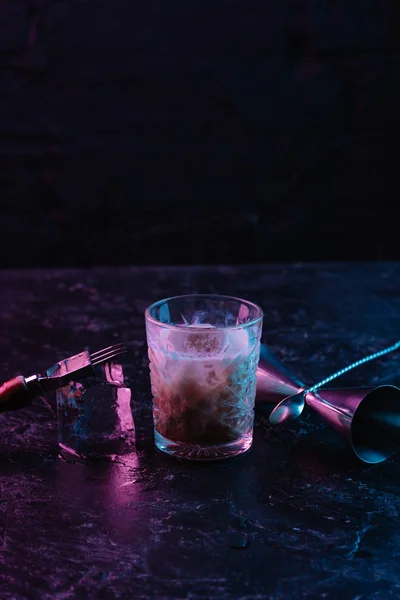 Close-up view of glass with delicious alcohol cocktail on dark surface — Stock Photo