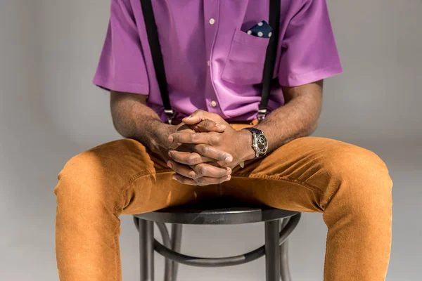 Cortado tiro do homem americano africano com as mãos na fechadura sentado na cadeira isolado no cinza — Fotografia de Stock