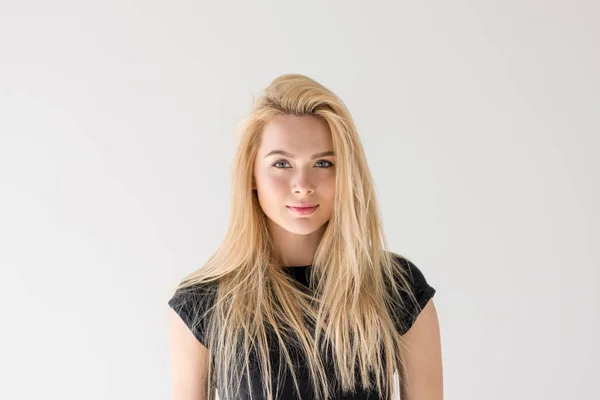 Porträt einer schönen jungen blonden Frau, die isoliert auf grau in die Kamera lächelt — Stockfoto