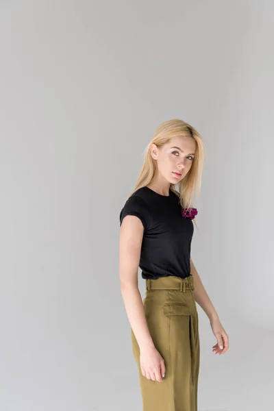 Beautiful young blonde woman looking at camera and standing isolated on grey — Stock Photo