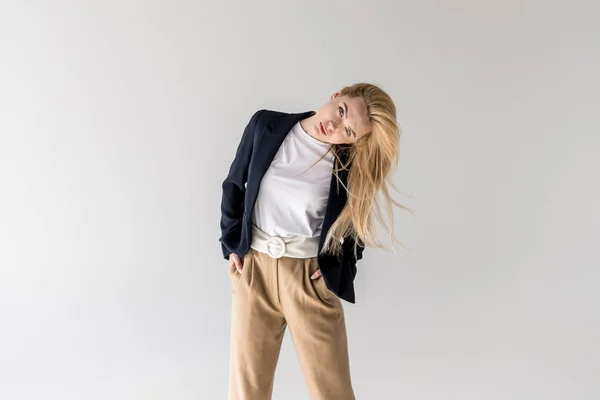 Portrait of beautiful young blonde woman looking at camera isolated on grey — Stock Photo