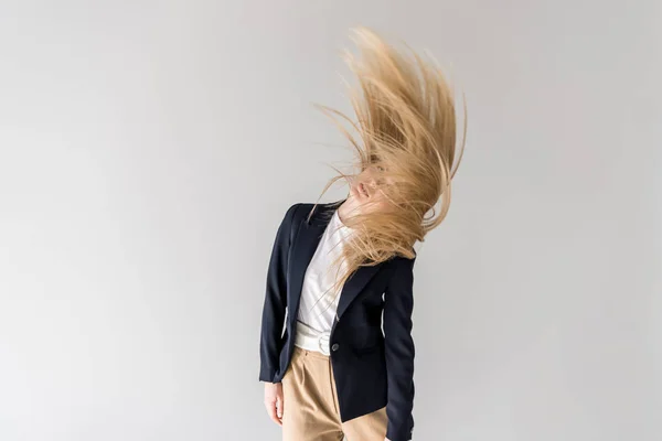 Beautiful stylish blonde girl shaking hair isolated on grey — Stock Photo