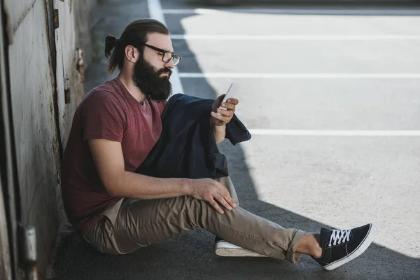 Katta oturan ve istimal telefon adam — Stok fotoğraf