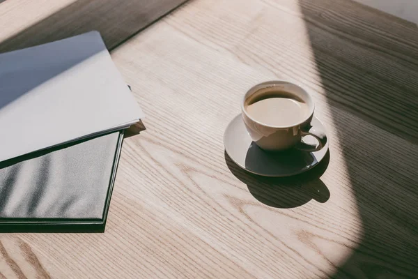 Xícara de café e cadernos na mesa — Fotografia de Stock